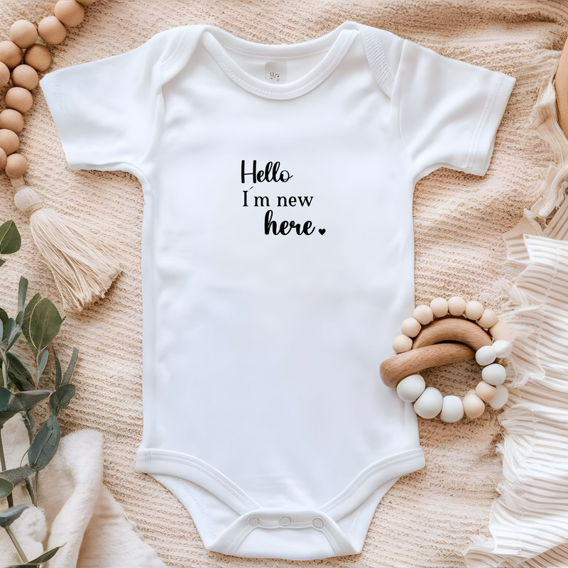 Kleines Bügelbild in Schwarz mit dem Motiv „Hello, I’m new here“. Ideal für Babybekleidung oder als süßes Geschenk zur Geburt.