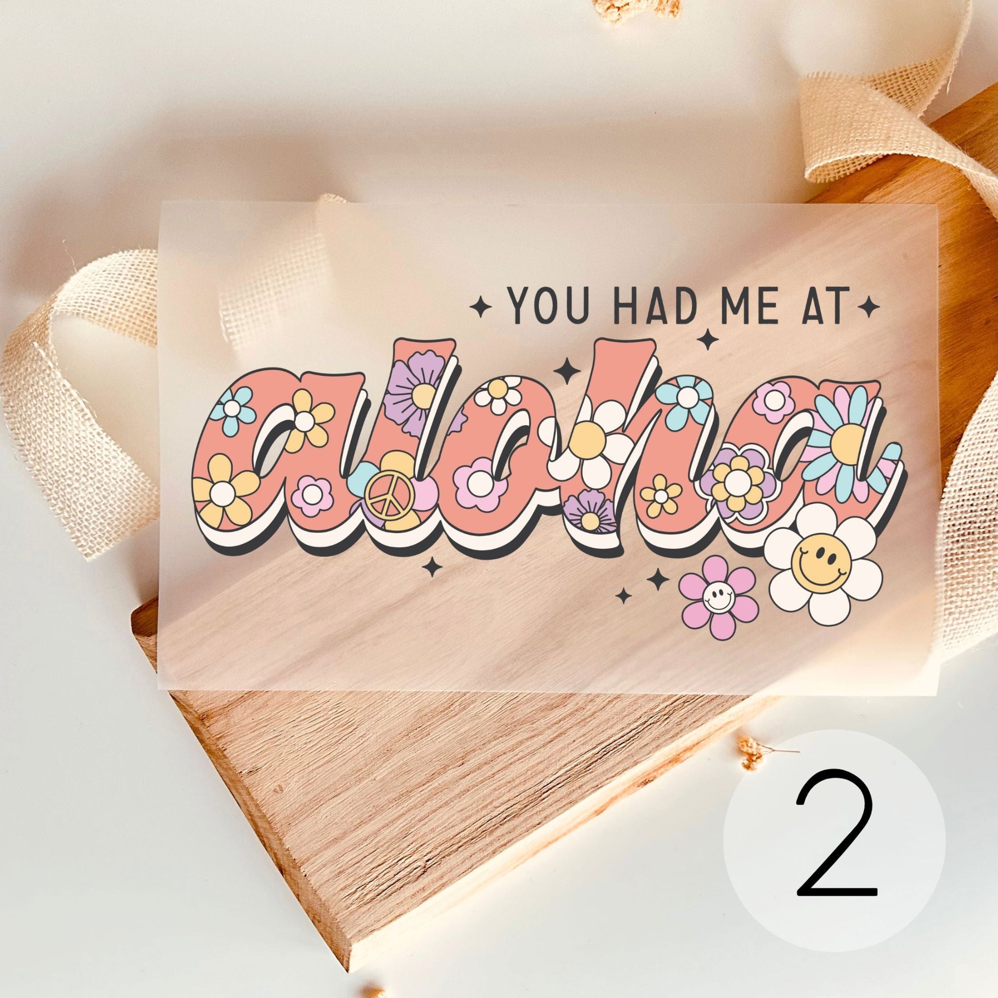 Bügelbild mit Schriftzug "You Had Me at Aloha" und bunten Retro-Blumen zum Aufbügeln