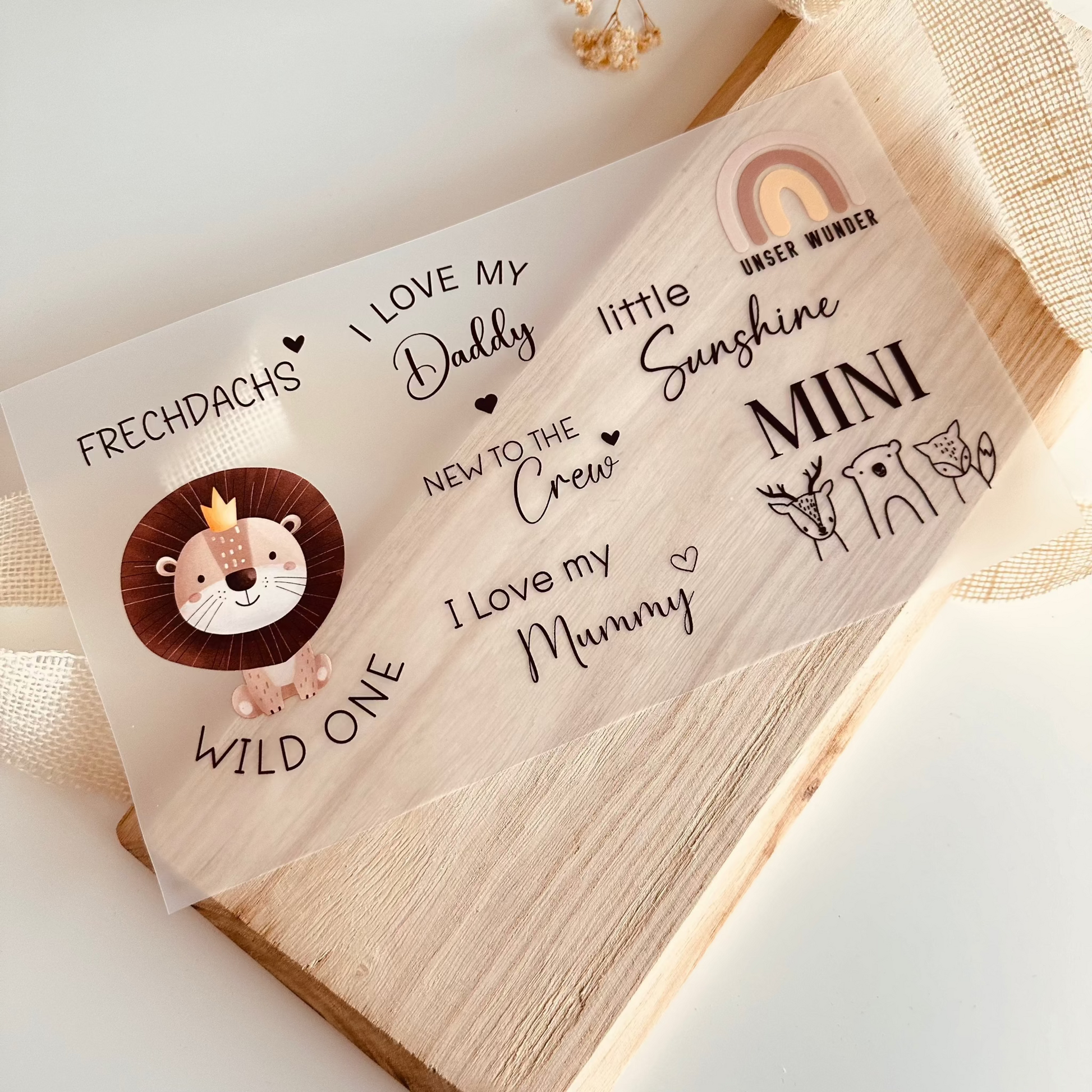 Bügelbild-Set mit Baby-Sprüchen wie "Wild One", "I Love My Daddy" und "New to the Crew" sowie Löwen-Motiv