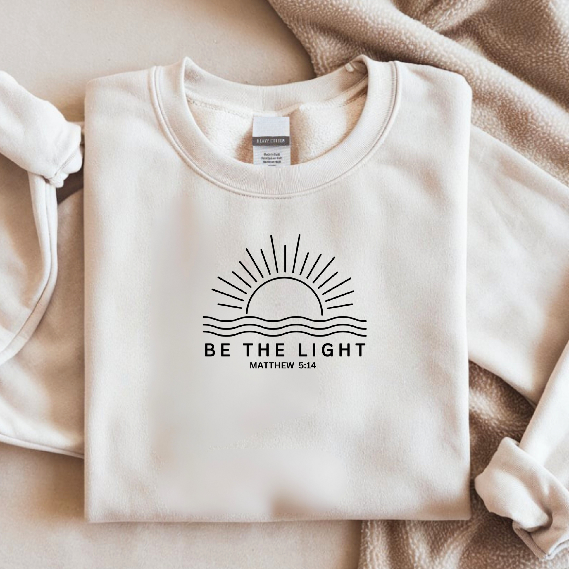 Bügelbild mit Sonnen-Motiv und Schriftzug "Be the Light" mit Bibelvers Matthäus 5:14 in Schwarz