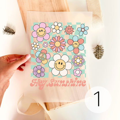 Bügelbild-Variante mit bunten Retro-Blumen, Smiley-Gesichtern und Schriftzug "Hey, Sunshine"