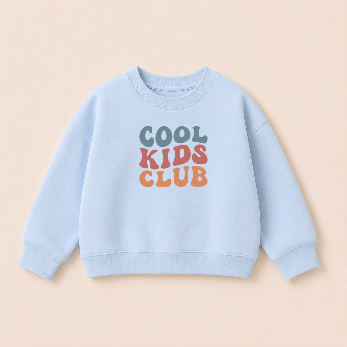 Bügelbild Cool Kids Club im Retro-Schriftzug in Blaugrau, Rosé und Orange, aufgebügelt auf hellblauem Kinder-Sweatshirt