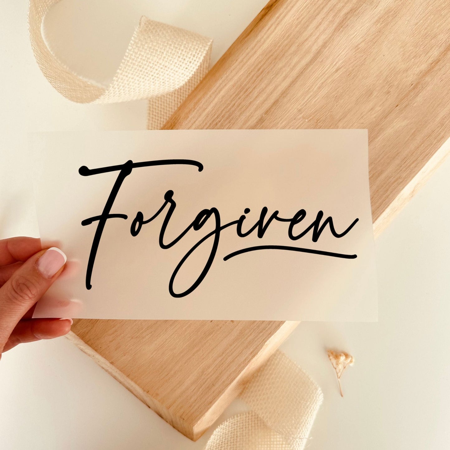 Bügelbild mit Schriftzug "Forgiven" in schwarzer Schreibschrift zum Aufbügeln