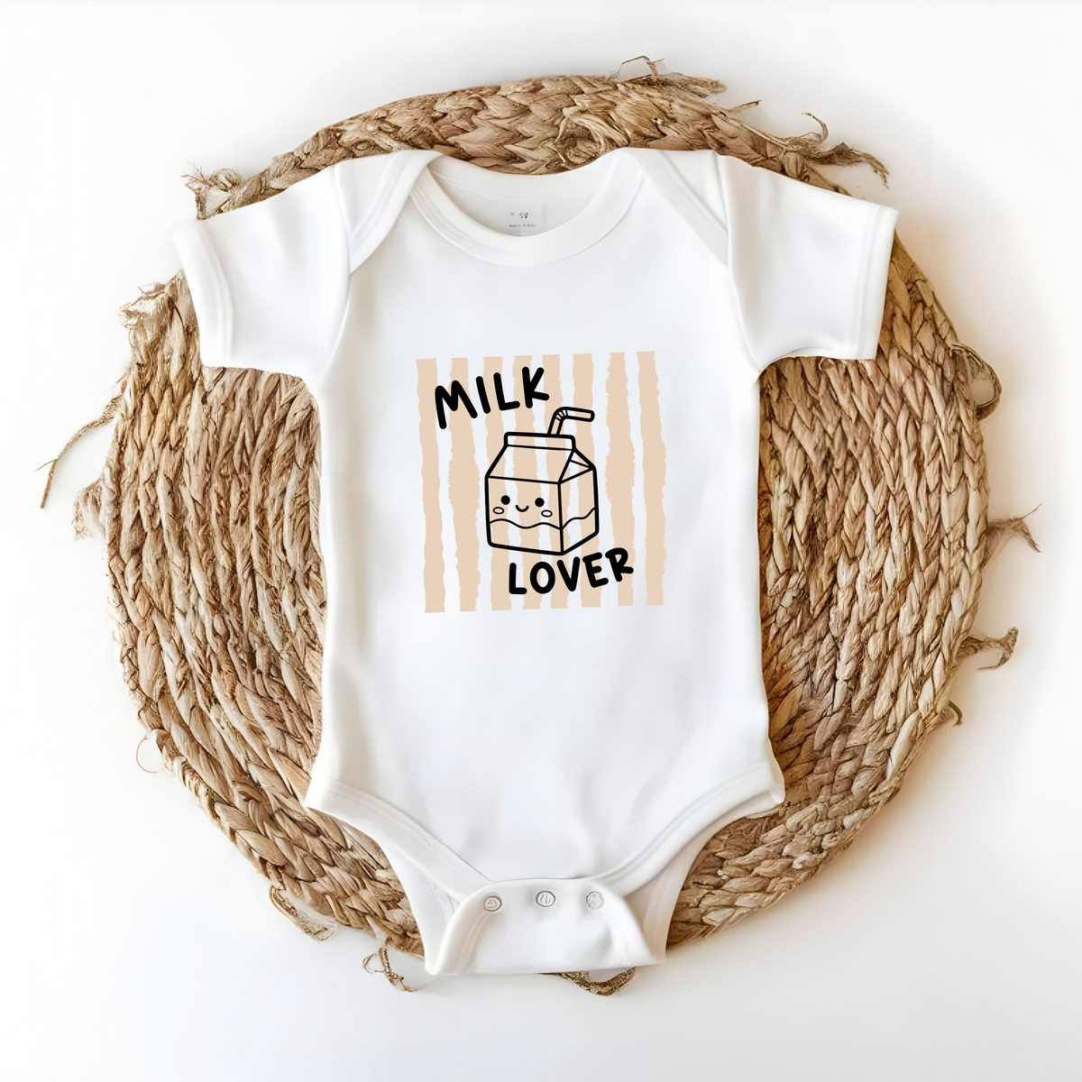 Bügelbild „Milk Lover“ mit süßer Milchtüte und beigen Streifen, aufgebügelt auf weißem Babybody. Bügelmotiv für Babykleidung, Geschenk zur Geburt oder Babyparty