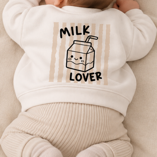 Bügelbild „Milk Lover“ mit Milchtüte und beigen Streifen, aufgebügelt auf Rücken von weißem Babypullover. Großes Rückenmotiv für Baby Outfit, Geschenk zur Geburt.
